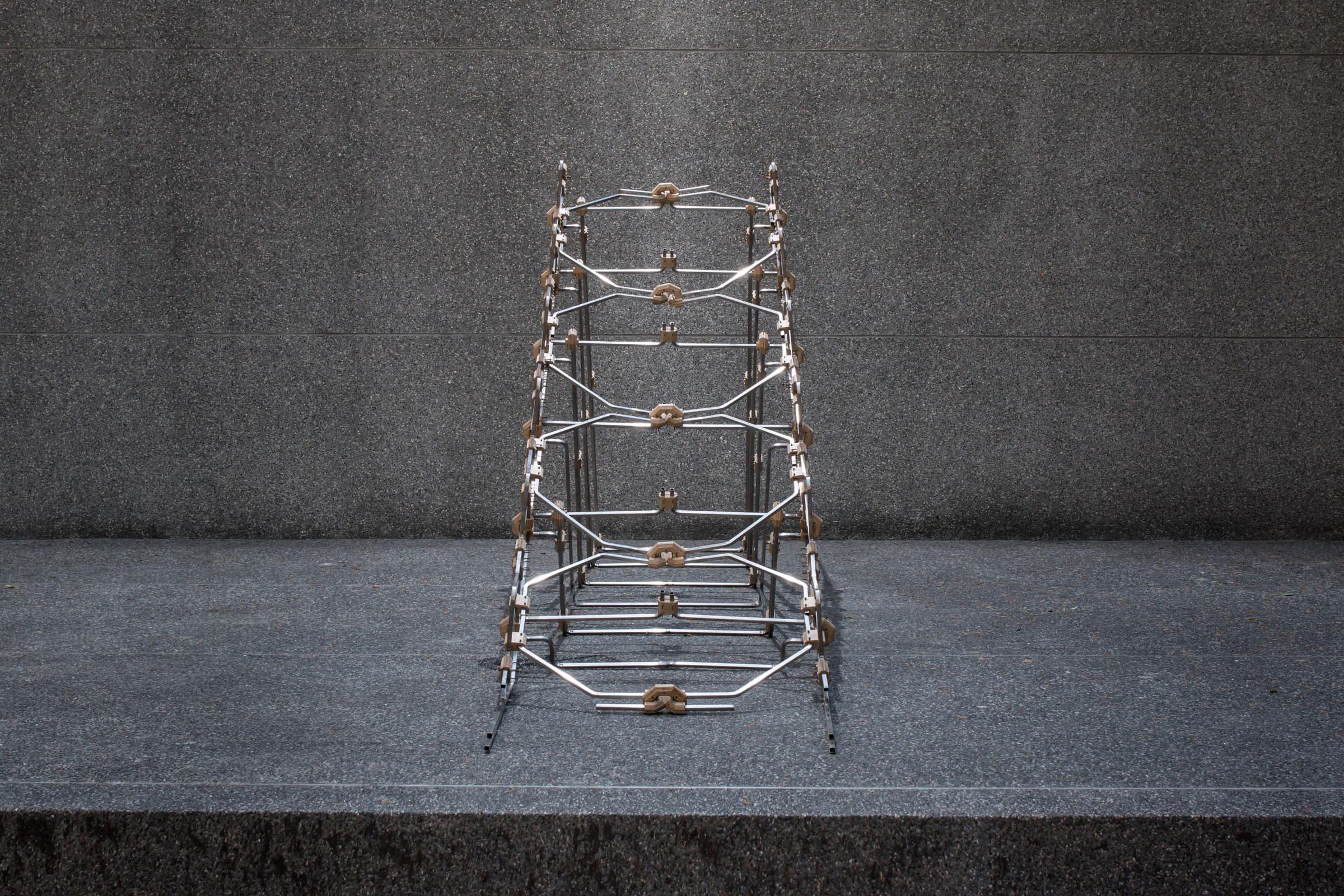Full-scale structure assembled from bent metal tubes.