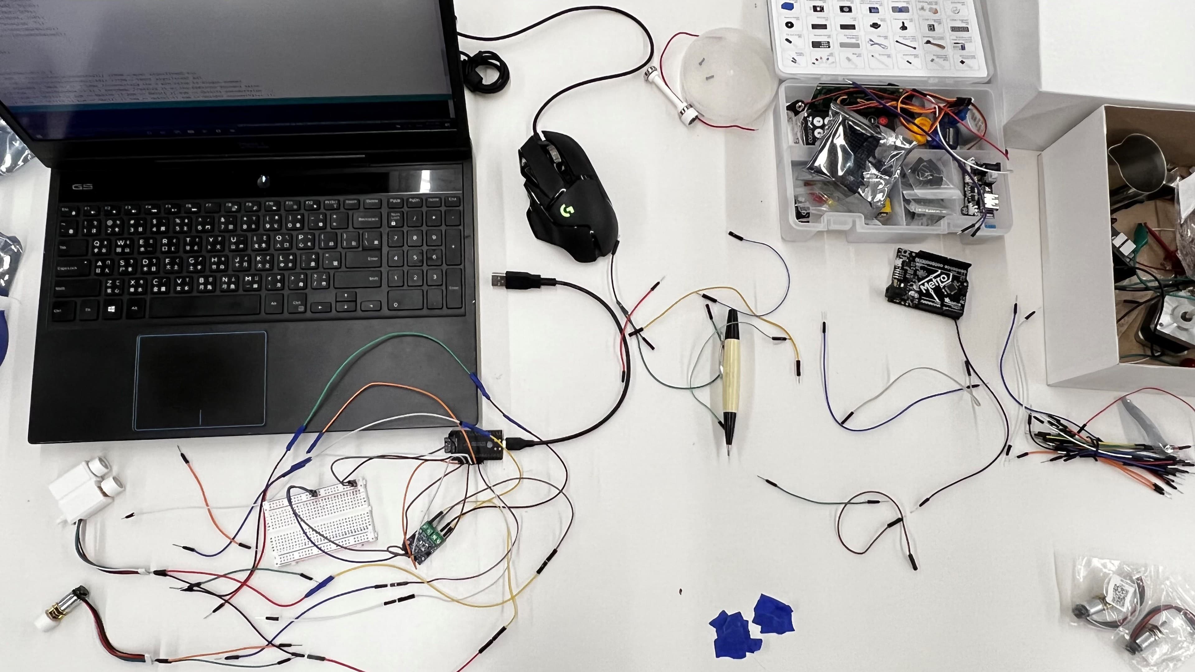 Climber electronics bench with laptop, breadboard, microcontroller, and wiring.